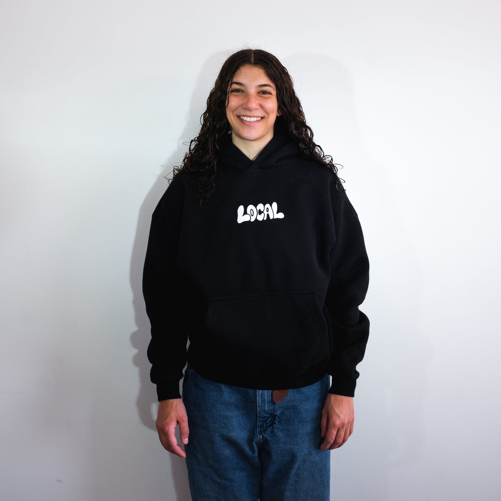 Person wearing a black hoodie with 'LOCAL' text on a white background