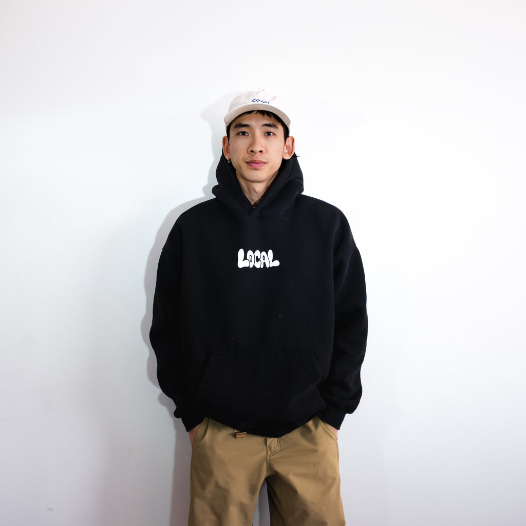 Person wearing a black hoodie with 'LOCAL' text on a white background