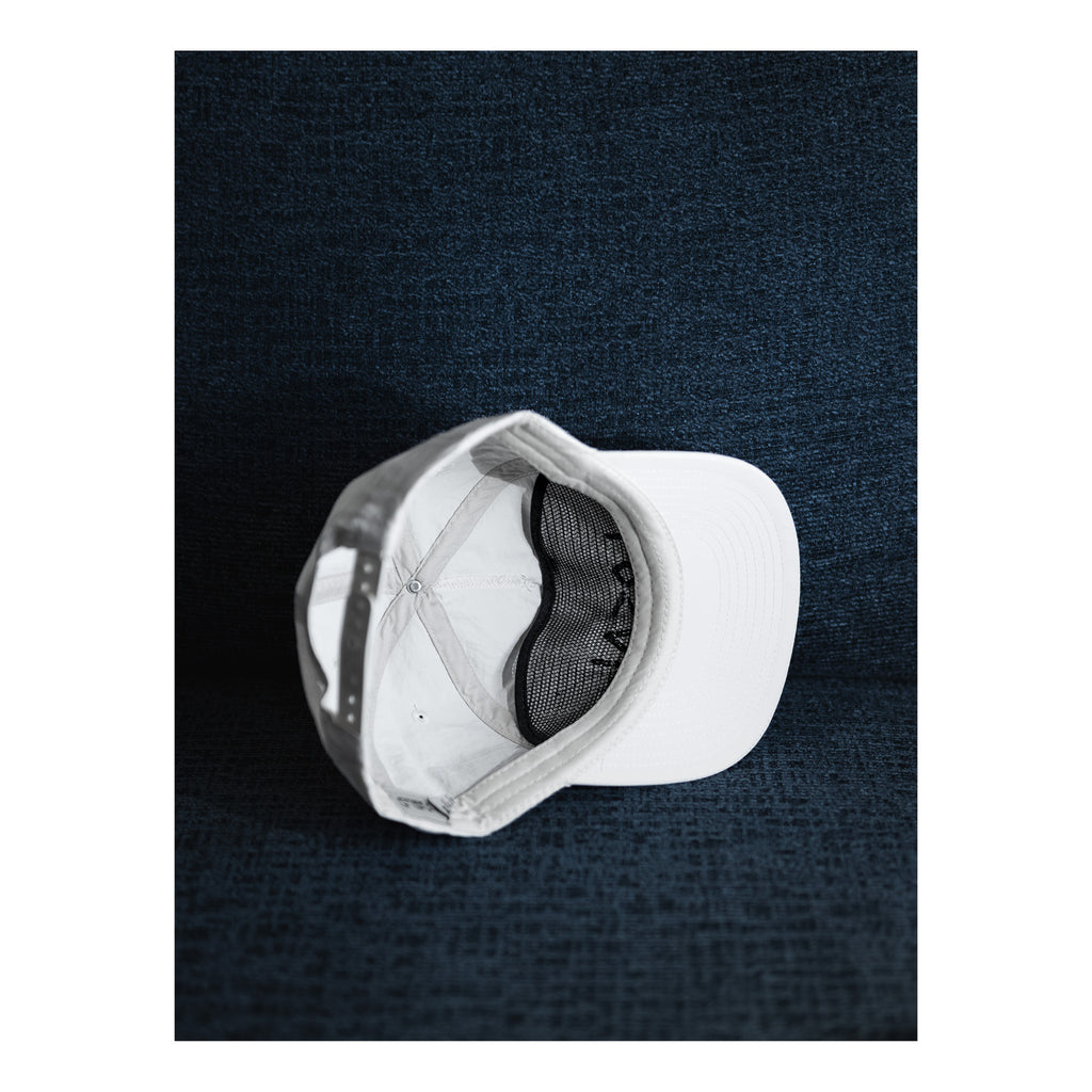 White baseball cap on a dark textured surface